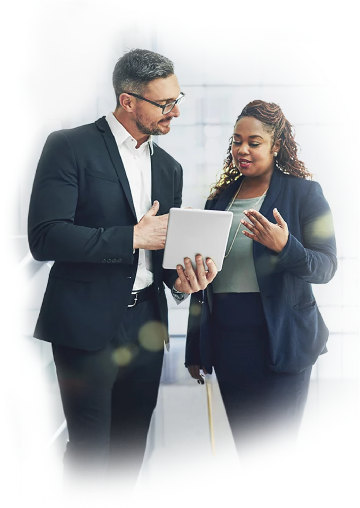 Business man and woman standing looking at iPad